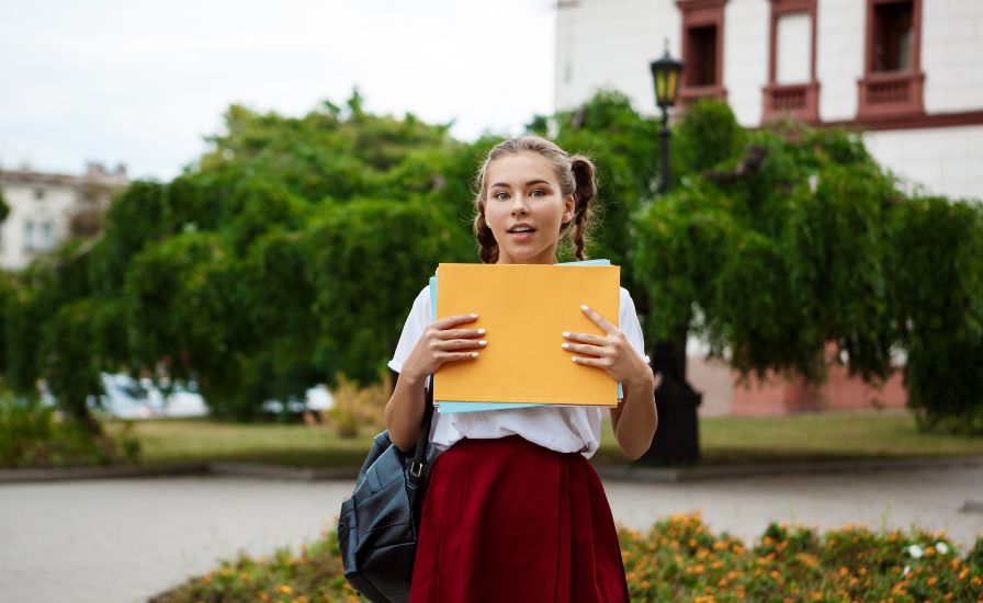 A girl at Queen Elizabeth School holding a folder in her hands
