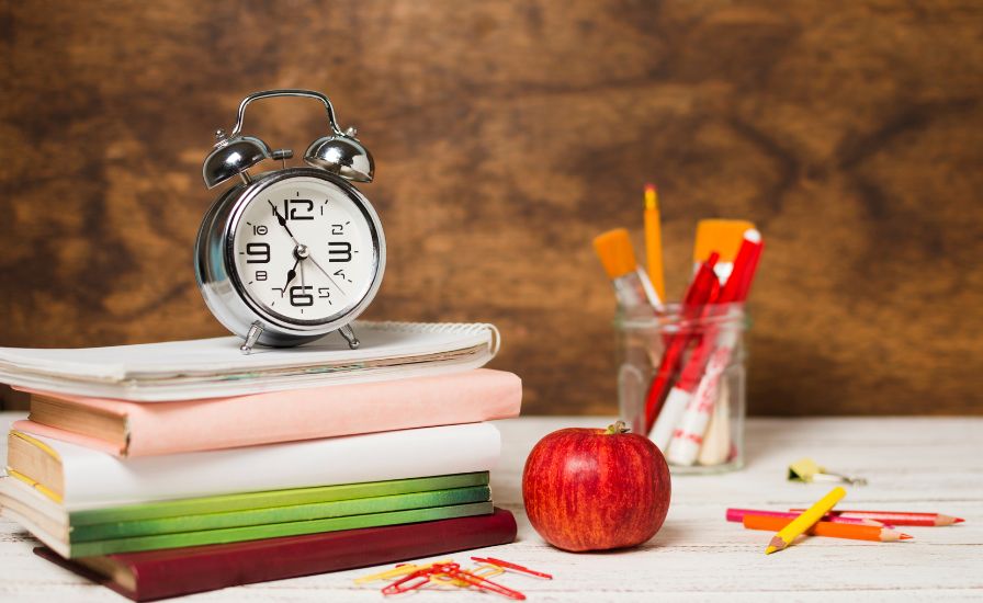 Alarm clock, books, and pencils symbolize back to school concept at Henrietta Barnett School