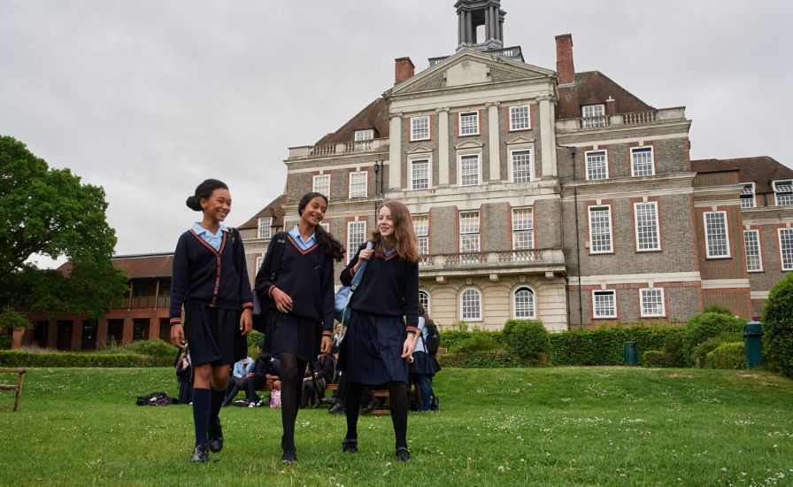Three girls in school uniforms standing in front of a large building, Henrietta Barnett School