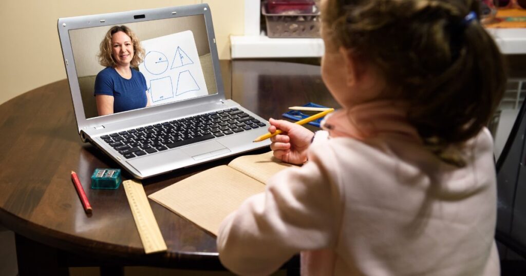 A young girl engrossed in a critical thinking challenge, sitting at a table with a laptop